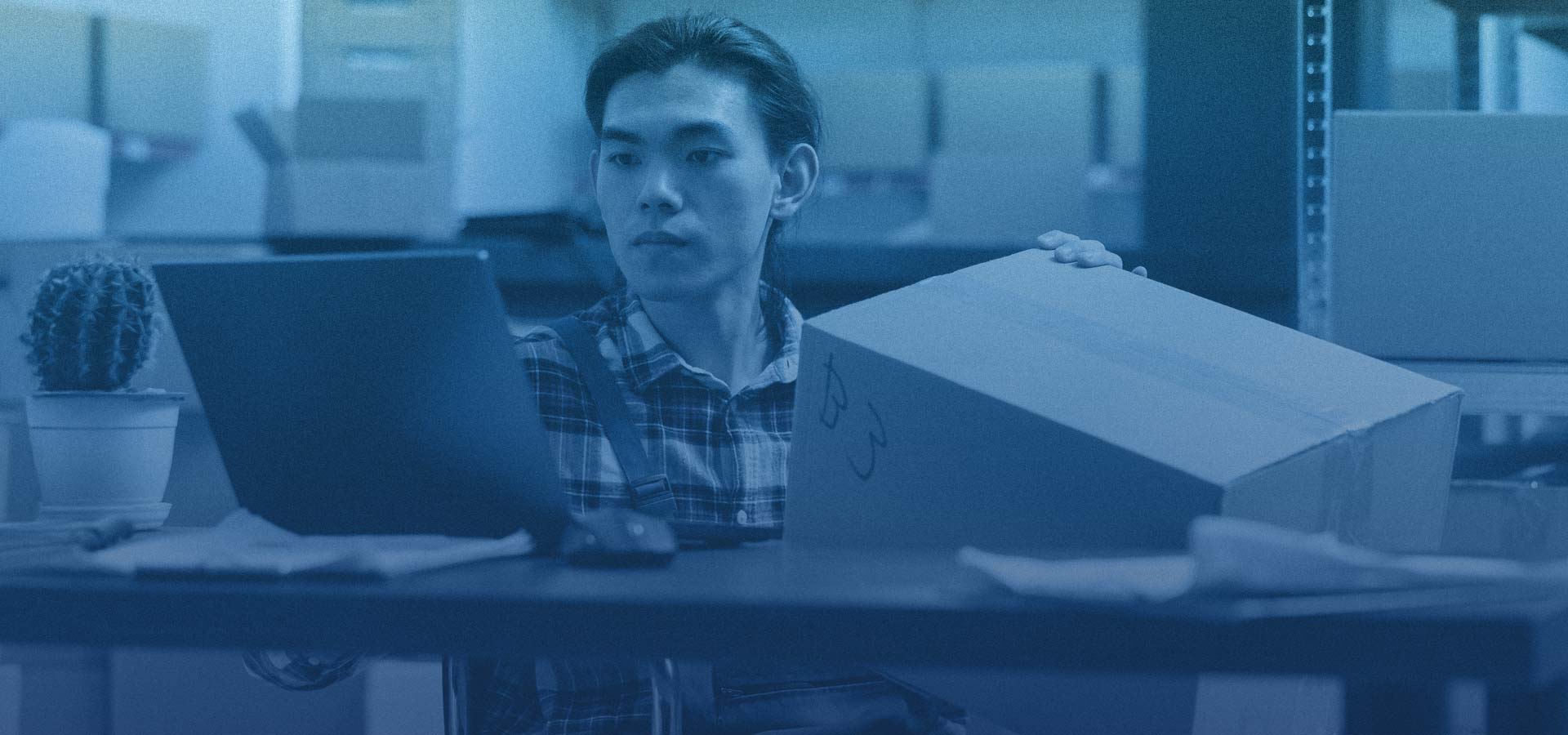Homem olhando para a tela de um computador analisando o estoque em seu sistema de Gestão